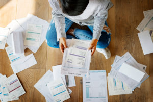 woman looking at numerous bills